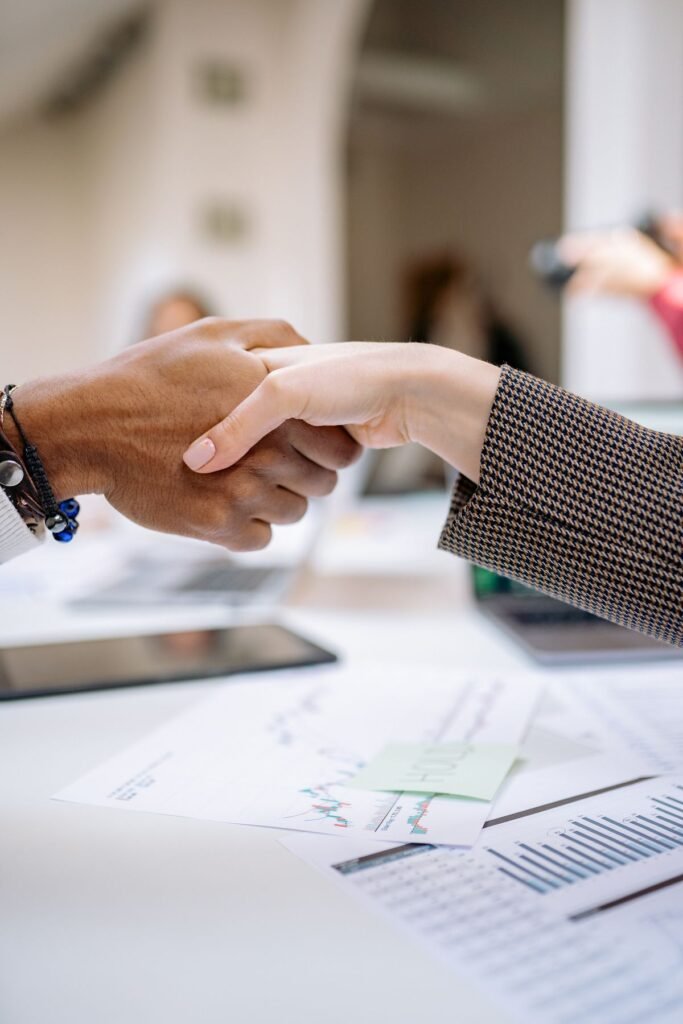 Professional handshake over business documents symbolizing integrity