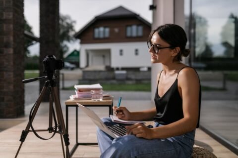 Profesional tomando notas durante un curso en línea en una laptop