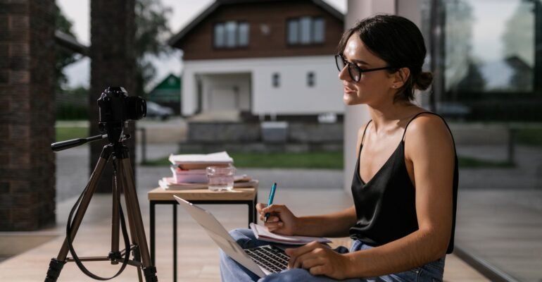 Profesional tomando notas durante un curso en línea en una laptop