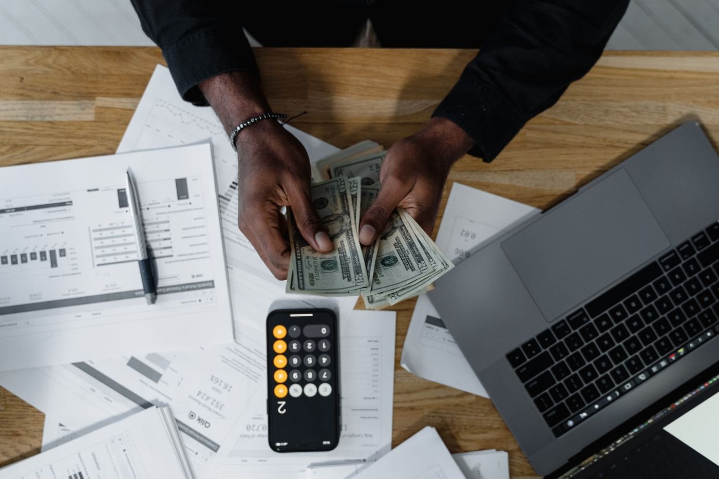 Persona revisando dólares con una calculadora