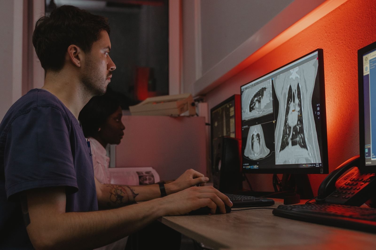 Dos especialistas revisando radiografias de torax en monitores